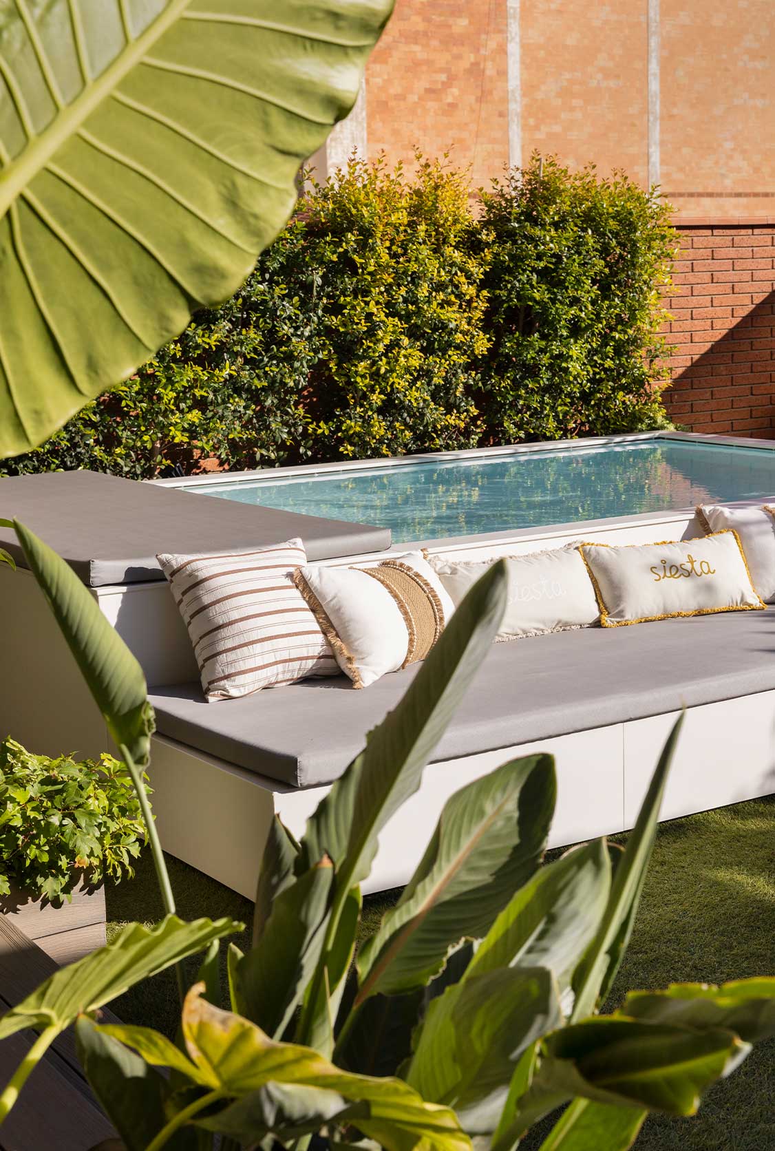Jardín decorado con sofá y piscina Jardín decorado con sofá y piscina