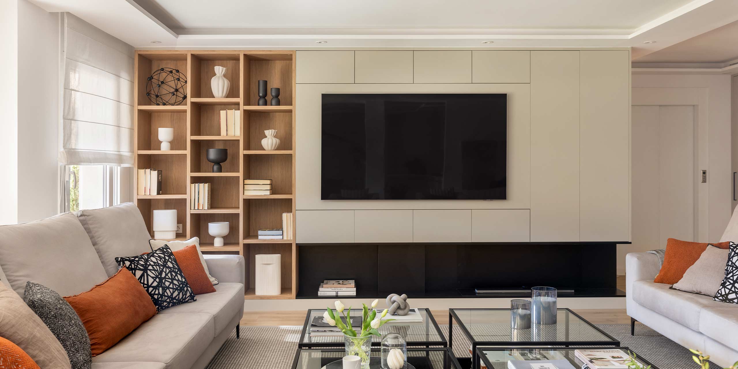 Salón con sofá y mueble decorado junto a televisor Salón con sofá y mueble decorado junto a televisor