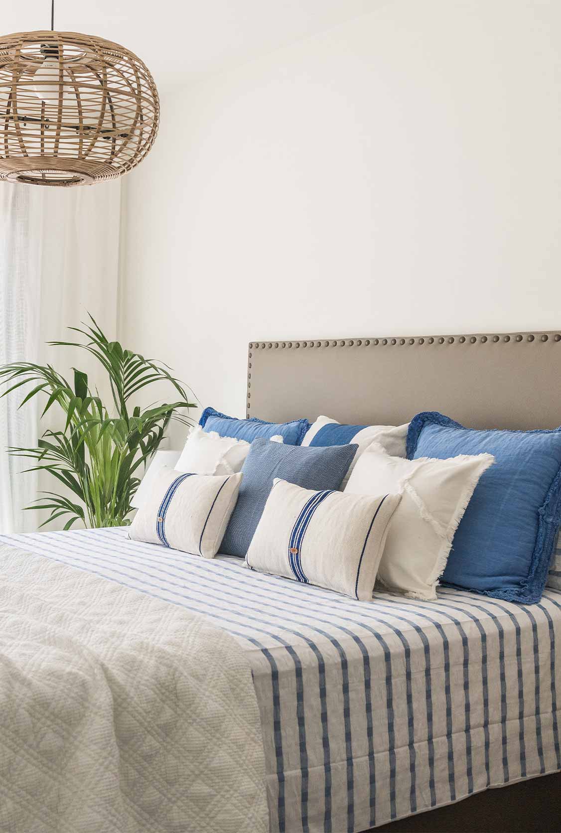 Cama con cojines y planta Cama con cojines y planta